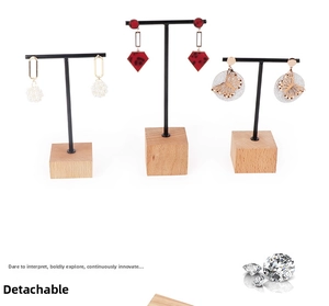 Macro detail of three black metal T-bar earring stands with rustic square wooden bases