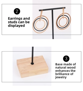 Detail of black metal T-bar earring stand with natural wooden base texture