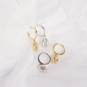 Close-up of gold and silver S925 sterling silver hoop earrings with delicate shell pendants