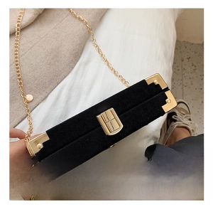 Detail view of the luxury black velvet box bag featuring golden metal frame and lock
