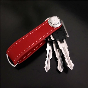 Macro detail of red leather key organizer with white stitching and metal hardware