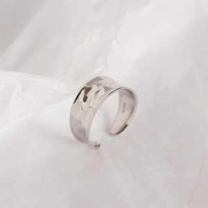 Detailed macro view of an irregular textured S925 sterling silver wide band ring