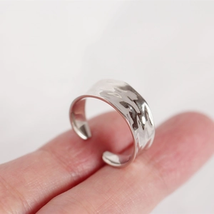 Macro shot of minimalist hammered S925 sterling silver wide open ring for women
