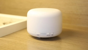 Detail of ultrasonic diffuser buttons for light, mist, and timer settings on wooden desk