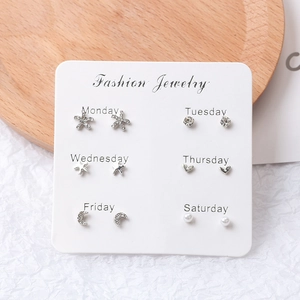 Detail of 6-pair earring set featuring stars, moon, and pearls on a weekly planner card