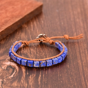 Close-up of bohemian blue square stone yoga bracelet with woven cord on wooden background