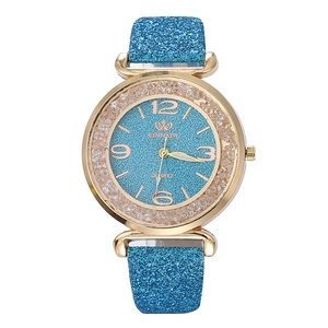 Dettaglio della lunetta dorata con strass e del quadrante blu glitterato dell'orologio
