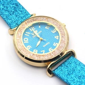 Dettaglio del cinturino blu glitterato e lunetta in cristallo con cassa in oro e numeri