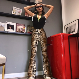 Detail shot of tiger print flared trousers with elastic high waist and knit fabric texture