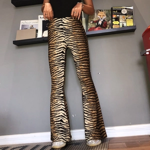 Women's high waist flared pants featuring a bold tiger print pattern in a slim fit style