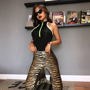 Close-up of stylish leopard print flared trousers paired with a black zipper vest