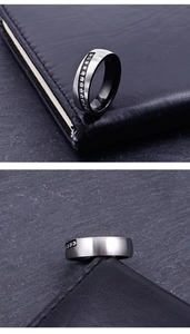 Close-up of matte brushed stainless steel ring with black inner band and inlaid cubic zirconia