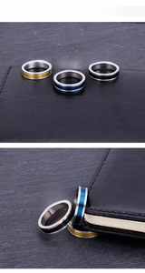 Détail de bagues 5mm en acier brossé doré bleu et noir sur un fond de roche sombre