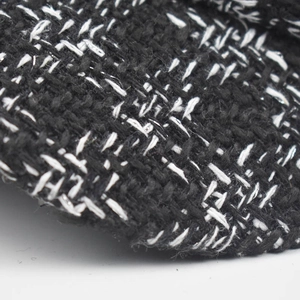 Detailed view of black and white tweed fabric with silver glitter silk woven texture