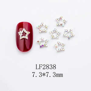 Detail of silver star nail charms with AB rhinestones on red nails, size 7.3mm