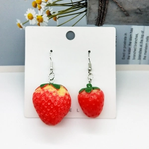 Asymmetric cute resin strawberry earrings with green leaves on white card background