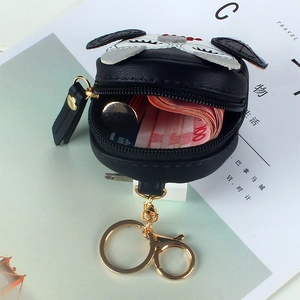 Cute black owl coin purse with gold keychain and zipper for women on magazine background