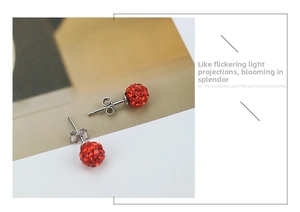 Detailed macro view of 925 sterling silver ball earrings featuring sparkling red crystals