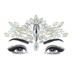 Close-up of crown-shaped luminous AB crystal face gems on a makeup drawing template