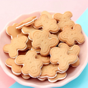 Macro shot of gingerbread man resin charms in a pink plate for DIY craft decoration