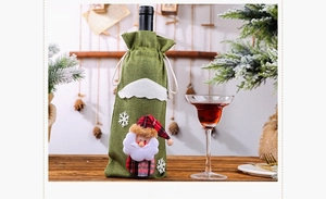 Detail view of green burlap Christmas wine bottle bag with festive Santa Claus figure
