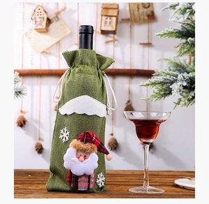 Close-up of green burlap Christmas wine bottle bag with 3D Santa and snowflake embroidery