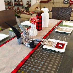 Close-up of rustic Christmas table runner and cutlery pockets with lace and bow details