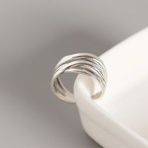 Detail shot of a S925 sterling silver multi-layer woven ring on white ceramic edge