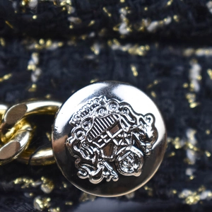 Macro detail of plaid wool fabric with metallic threads and engraved silver button