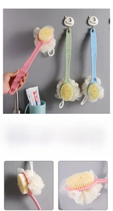 Detail of long-handle bath brush showing soft bristles and integrated white bath sponge