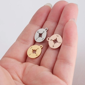 Three minimalist stainless steel compass pendants in silver, gold, and rose gold finishes