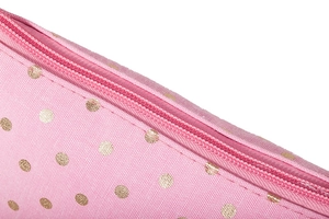 Detail of pink fabric makeup bag with gold polka dots and a sturdy matching zipper