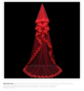 Close-up of red wedding veil featuring intricate lace embroidery on the wavy mesh edges