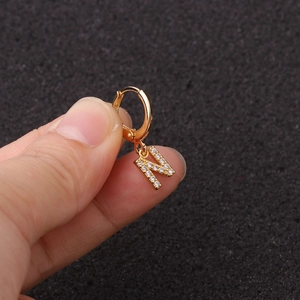 Détail d'une créole en or pour cartilage avec pendentif lettre N serti de zircons