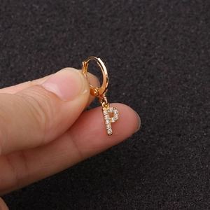 Détail d'une boucle d'oreille lettre P dorée avec oxydes de zirconium sur un petit anneau