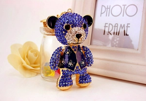 Detail of bear keychain with dark blue rhinestones and intricate golden metal frame