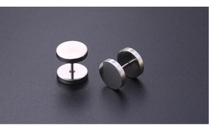 Macro shot of silver titanium steel barbell studs with polished round double-headed design