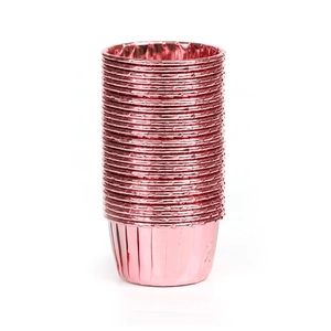 Gros plan de caissettes à cupcakes en aluminium or rose brillant avec bords plissés