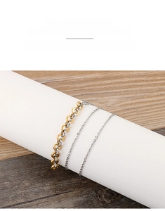 Détail d'un bracelet double couche en acier inoxydable avec des chaînes dorées et argentées