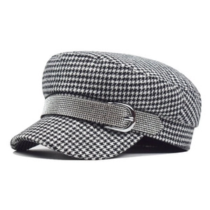 Detail of newsboy hat with black white houndstooth pattern and rhinestone chain