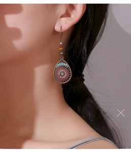 Gros plan détaillé de boucles d'oreilles bohèmes en bronze avec perles et motifs floraux