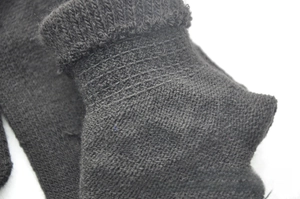 Macro shot of the ribbed cuff detail on black knitted skeleton gloves for kids