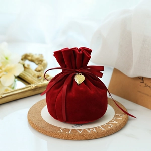 Elegant red velvet wedding candy bag with gold heart pendant and satin ribbon bow