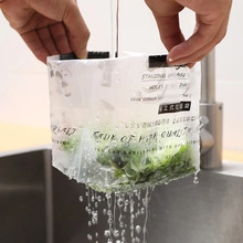 Close-up of self-standing kitchen drain bag showing water filtering in a sink