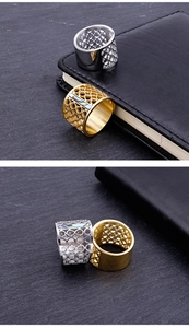 Close-up of cutout geometric stainless steel rings in gold and silver finishes