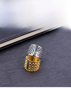 Macro detail of wide hollow stainless steel rings with colorful shell inlay