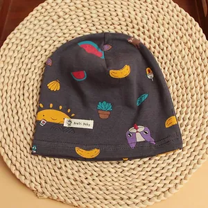 Detail of baby cotton knit hat with colorful cartoon sun, banana and puppy prints