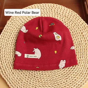 Detailed view of burgundy cotton baby beanie featuring a polar bear cartoon print