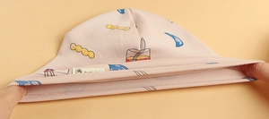 Detail shot showing the high elasticity and ribbed knit texture of a pink baby cotton hat