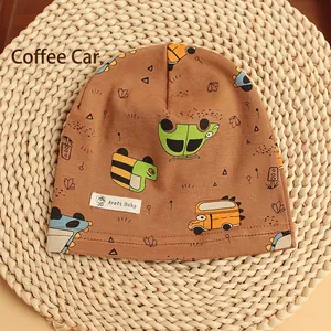 Close-up of soft coffee cotton knit baby hat featuring colorful cartoon car patterns